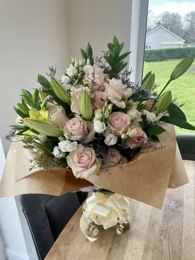 A blush rose and lily bouquet in kraft wrap