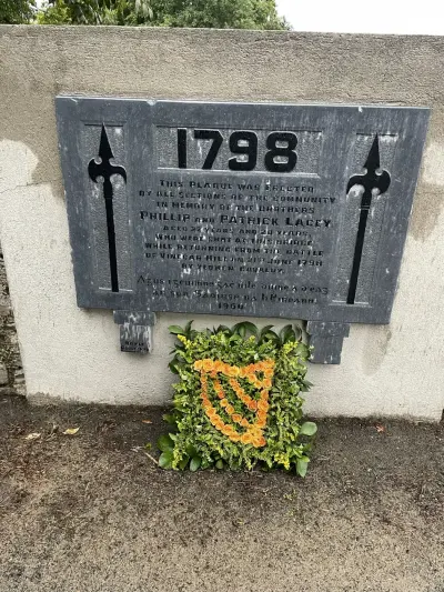 A floral harp tribute beneath the 1798 memorial plaque