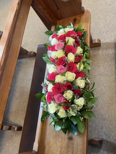 A long red and white rose casket arrangement