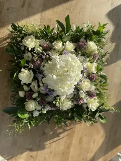 A square white and lilac sympathy arrangement