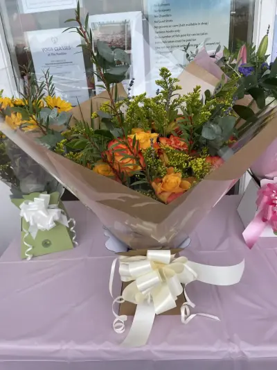 A wrapped autumn bouquet with a cream bow