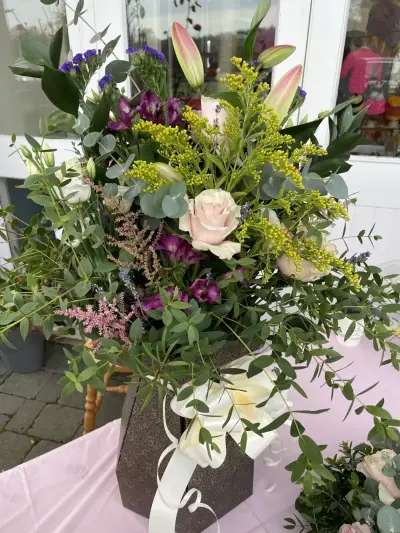 A tall bouquet with lilies and solidago